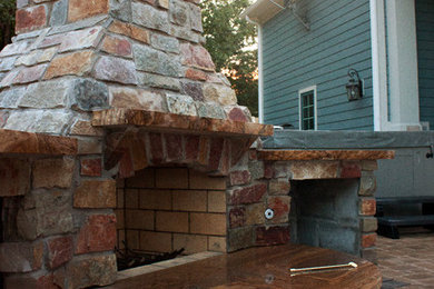 Example of a mid-sized backyard concrete paver patio design in St Louis with a fire pit and a gazebo