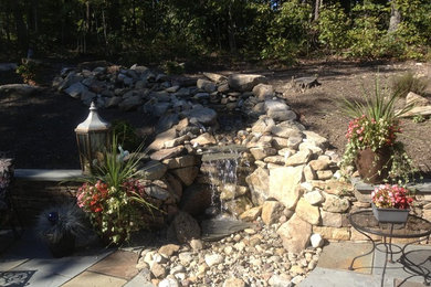 Mid-sized elegant backyard stone patio fountain photo in Other with no cover