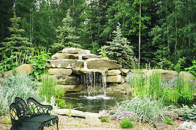 Inspiration for a backyard stone patio fountain remodel in Other with no cover