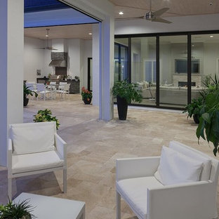 Idee per un patio o portico moderno di medie dimensioni e dietro casa con piastrelle e un tetto a sbalzo