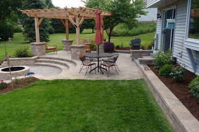 Mid-sized elegant backyard brick patio photo in Milwaukee with a fire pit and a pergola