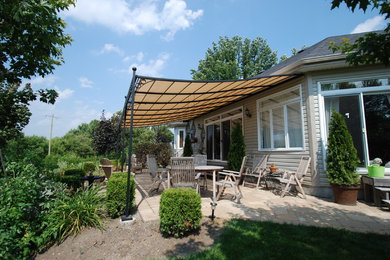 Large transitional backyard patio photo in Toronto with a pergola