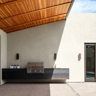 Idee per un patio o portico american style in cortile con lastre di cemento e un tetto a sbalzo