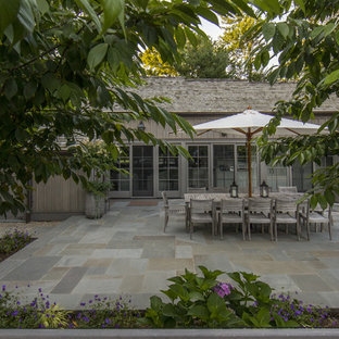Esempio di un patio o portico country di medie dimensioni e dietro casa con pavimentazioni in pietra naturale e nessuna copertura