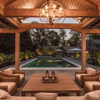 Example of a mid-sized country backyard stone patio design in New York with a gazebo