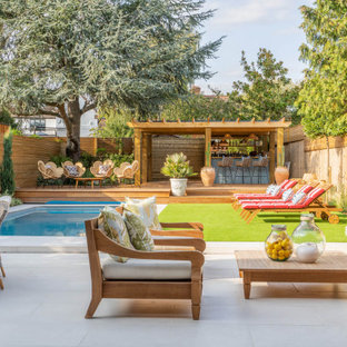 Design ideas for a traditional back patio in London with an outdoor kitchen, tiled flooring and a pergola.