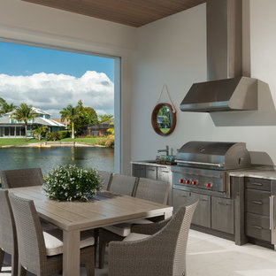 Inspiration for a transitional backyard patio kitchen remodel in Miami with a roof extension