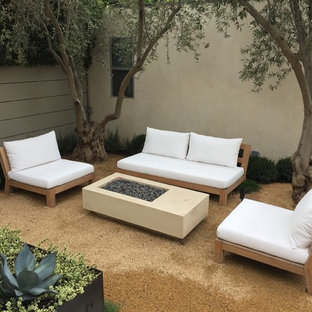Immagine di un patio o portico moderno di medie dimensioni e dietro casa con un focolare, graniglia di granito e nessuna copertura