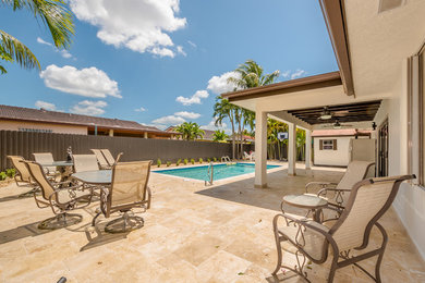 Mid-sized trendy backyard tile patio photo in Miami with a roof extension