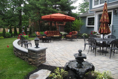 Inspiration for a large timeless backyard concrete paver patio fountain remodel in New York