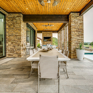 Immagine di un grande patio o portico minimalista dietro casa con piastrelle e un tetto a sbalzo