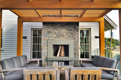Design ideas for a medium sized coastal back patio in New York with a fire feature, natural stone paving and a pergola.