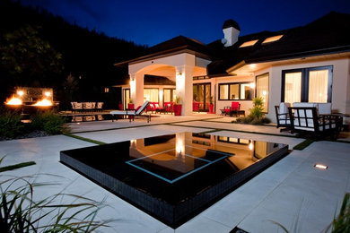 Inspiration for a huge contemporary backyard brick patio remodel in Vancouver with a roof extension