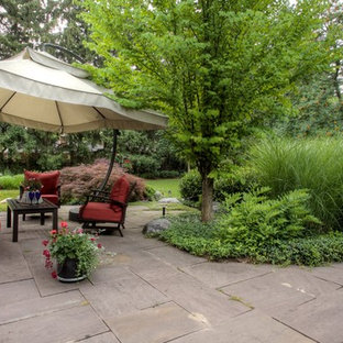Immagine di un ampio patio o portico boho chic dietro casa con pavimentazioni in pietra naturale