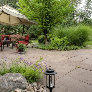 Foto di un ampio patio o portico boho chic dietro casa con pavimentazioni in cemento