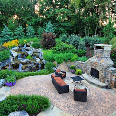 Inspiration for a large timeless backyard brick patio remodel in DC Metro with a fireplace