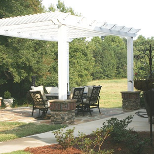 Ispirazione per un patio o portico eclettico di medie dimensioni e nel cortile laterale con pavimentazioni in pietra naturale e una pergola
