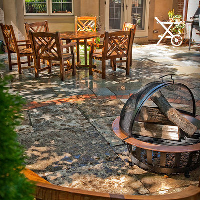 Example of a mid-sized classic backyard stone patio design in Milwaukee with a fire pit