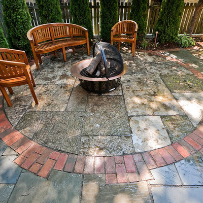 Inspiration for a mid-sized timeless backyard stone patio remodel in Milwaukee with a fire pit