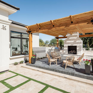 Immagine di un ampio patio o portico tradizionale dietro casa con un focolare, pavimentazioni in pietra naturale e una pergola