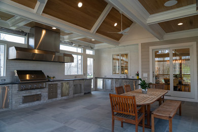Large elegant backyard concrete paver patio kitchen photo in DC Metro with a roof extension