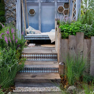 Immagine di un patio o portico boho chic con pedane e un gazebo o capanno