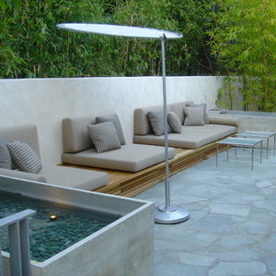 Ispirazione per un patio o portico minimal con pavimentazioni in pietra naturale e nessuna copertura