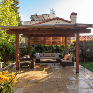 Example of a small eclectic backyard stone patio kitchen design in San Francisco with a pergola