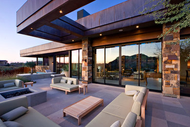 This is an example of an expansive contemporary back patio in Los Angeles with concrete paving.