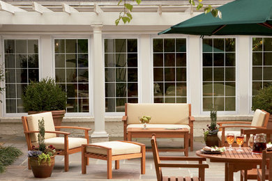 Foto de patio de estilo americano de tamaño medio en patio trasero con cocina exterior, adoquines de piedra natural y pérgola