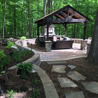 Ispirazione per un patio o portico american style di medie dimensioni e dietro casa con un focolare, pavimentazioni in mattoni e un gazebo o capanno