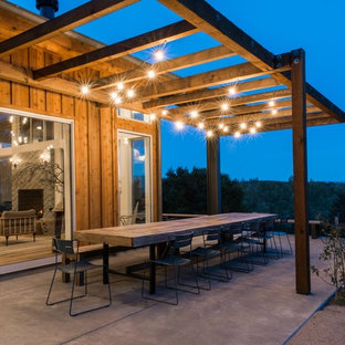 Esempio di un patio o portico country dietro casa con una pergola