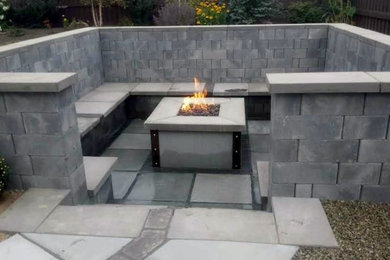 Inspiration for a mid-sized contemporary backyard concrete paver patio remodel in Boise with a fireplace and no cover