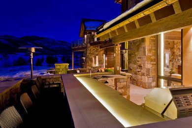 Example of a large mountain style backyard patio kitchen design in Denver with no cover