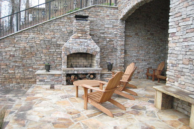 Ejemplo de patio de tamaño medio sin cubierta en patio trasero con brasero y adoquines de piedra natural