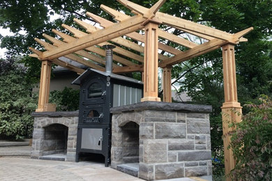 Foto de patio tradicional de tamaño medio en patio lateral con adoquines de piedra natural, pérgola y cocina exterior