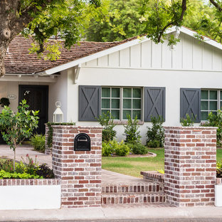 Immagine di un grande patio o portico stile americano davanti casa con pavimentazioni in mattoni e nessuna copertura