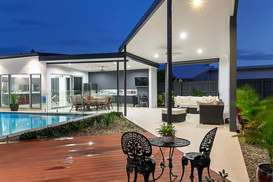 Foto di un ampio patio o portico moderno dietro casa con pedane e un tetto a sbalzo