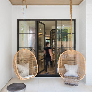 Foto di un patio o portico classico di medie dimensioni e dietro casa con un focolare, piastrelle e un tetto a sbalzo