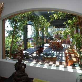 Ispirazione per un grande patio o portico etnico dietro casa con piastrelle e una pergola