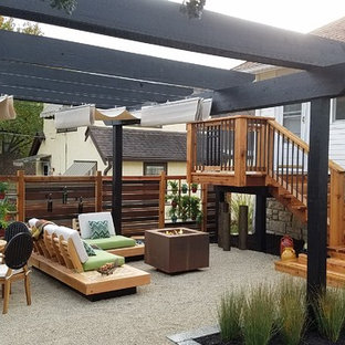 Foto di un piccolo patio o portico moderno dietro casa con graniglia di granito e una pergola