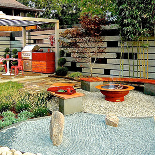 Idee per un patio o portico etnico dietro casa e di medie dimensioni con un focolare, ghiaia e una pergola
