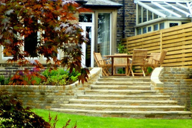 Inspiration for a contemporary back patio in Other with natural stone paving.