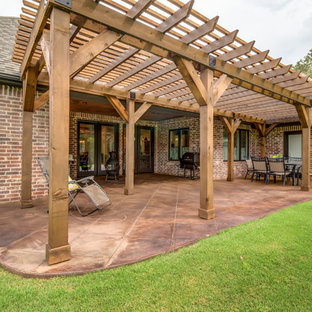 Idee per un patio o portico stile americano di medie dimensioni e dietro casa con cemento stampato e una pergola