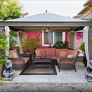 Ispirazione per un piccolo patio o portico etnico in cortile con cemento stampato e un gazebo o capanno