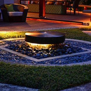 Esempio di un patio o portico etnico di medie dimensioni e dietro casa con un focolare, pedane e una pergola
