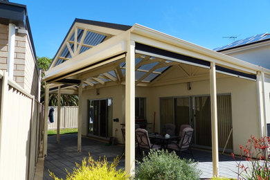 This is an example of a large modern back patio in Adelaide with a pergola.