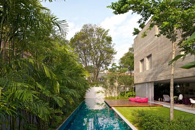 Imagen de casa de la piscina y piscina alargada exótica de tamaño medio rectangular en patio lateral