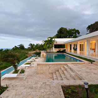 Ejemplo de piscina infinita, moderna, rectangular, con suelo de baldosas