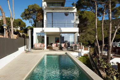 Imagen de casa de la piscina y piscina alargada contemporánea de tamaño medio rectangular en patio trasero con suelo de baldosas